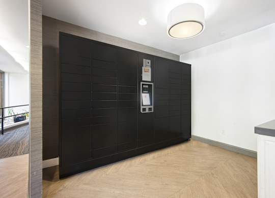 A modern kitchen with a black tile backsplash and wooden flooring.