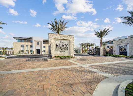 The image shows a modern building with a sign that reads  at The Max on Jefferson Apartments, Murrieta, CA