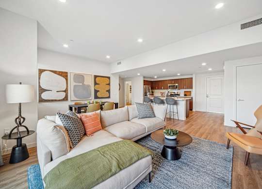 A living room with a white couch and a green throw pillow. at The Max on Jefferson Apartments, Murrieta, 92562