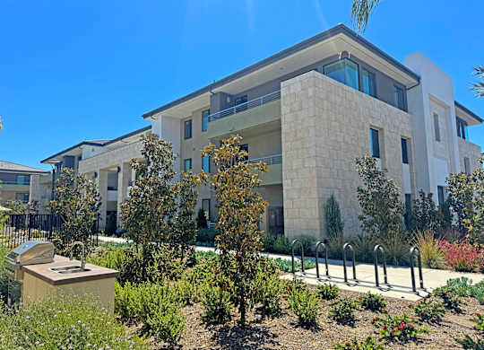 A modern building with a garden in front.