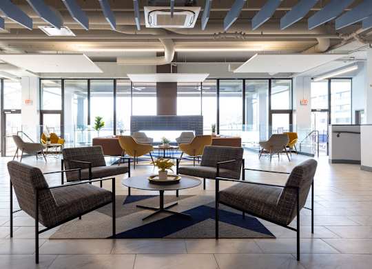 a large lobby with chairs and a table at The Residences at Tesson Ridge, Saint Louis, Missouri
