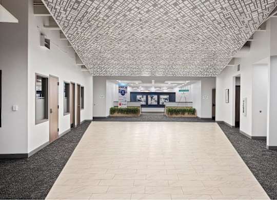 an empty hallway in a building with white walls and tiled floors at The Residences at Tesson Ridge, Saint Louis, 63128