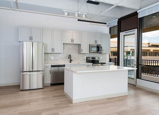 A modern kitchen with white cabinets and stainless steel appliances.