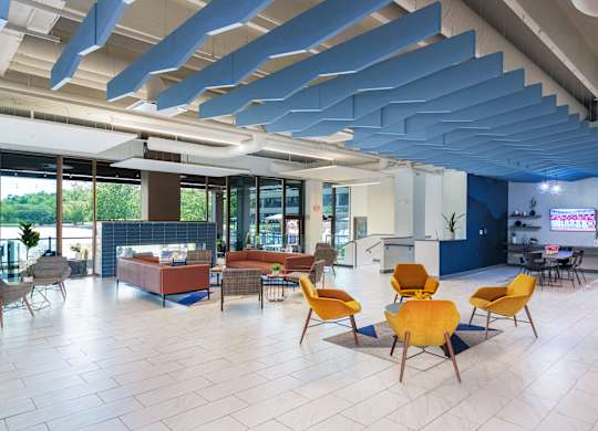 A modern open space with yellow chairs and a blue ceiling.