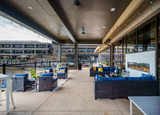 A patio area with blue couches and tables.