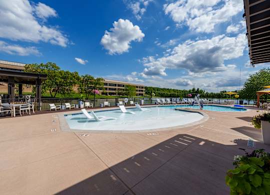 A large outdoor swimming pool with a fountain in the middle.