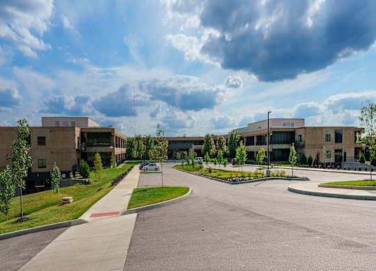 A large building complex with a parking lot in front.