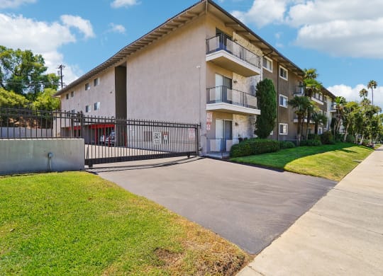 a white apartment building with a sidewalk and grass