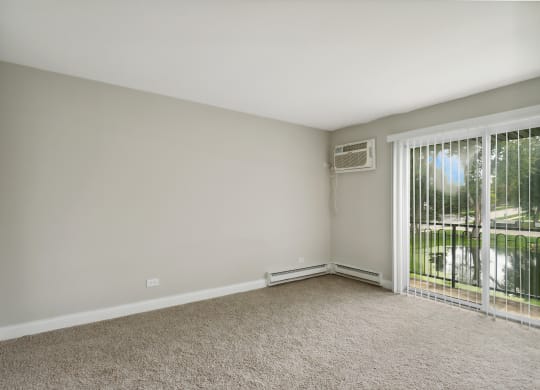 a bedroom with a sliding glass door and carpet at The Hinsdale, Hinsdale, 60521