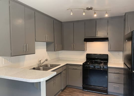 a kitchen with a stove a sink and a refrigerator at Dwell Apartment Homes, Riverside