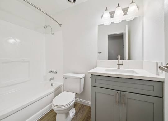 A white toilet sits next to a white sink in a bathroom.