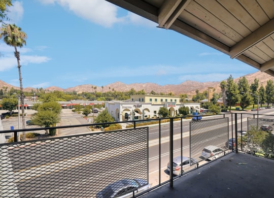 the view of the parking lot from the balcony of a building with a parking lot