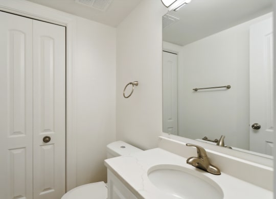 a bathroom with a white sink and toilet next to a white door at The Hinsdale, Hinsdale, Illinois