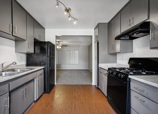 an empty kitchen with black appliances and white cabinets