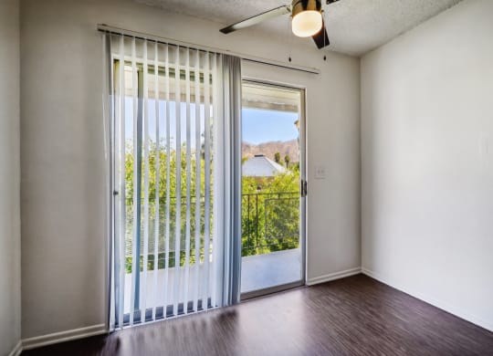an empty living room with a door to a balcony