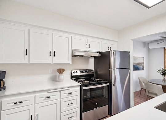 A kitchen with white cabinets and stainless steel appliances.