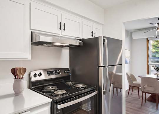 A modern kitchen with a stove, oven, and refrigerator.