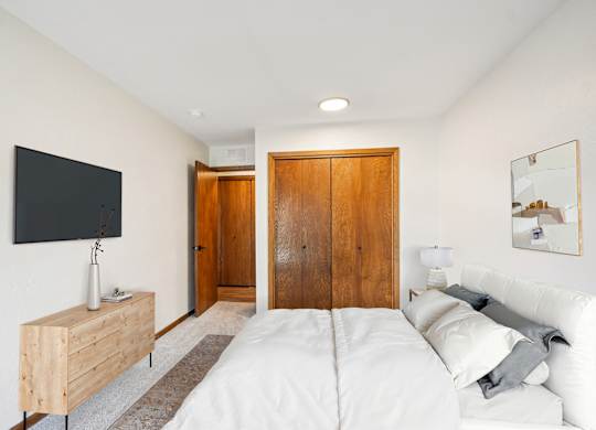 A bedroom with a bed, a dresser, and a mirror.