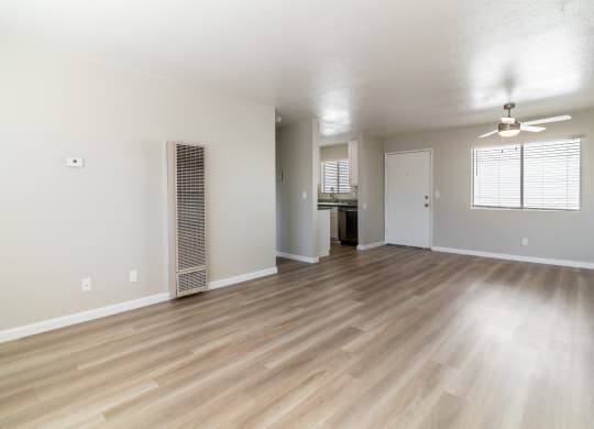an empty living room with hardwood flooring and a kitchen at Alturas Paso Robles Apartment Homes, California