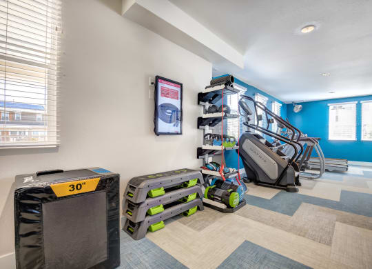 a home gym with a treadmill and a television