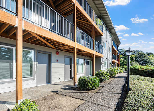 A sunny day at a modern apartment complex with a clear blue sky.