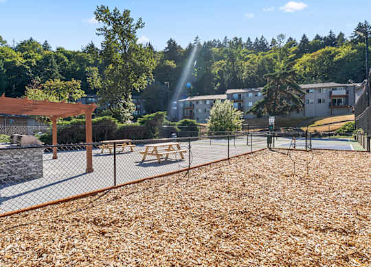 A playground with a wooden structure and a fence.