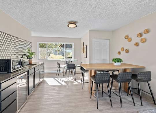 A kitchen with a dining table and chairs.