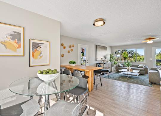 A modern dining room with a glass table and chairs.
