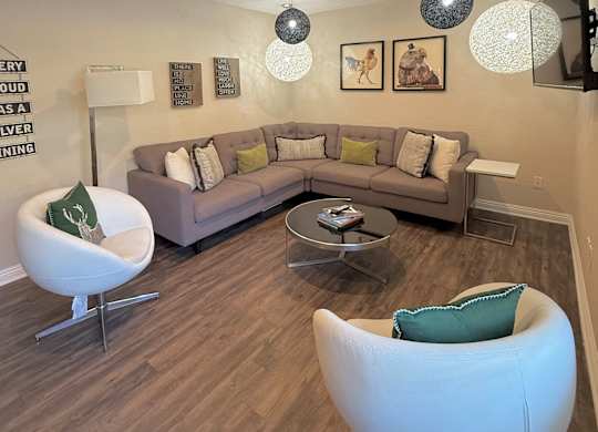 A living room with a grey couch, a white chair and a coffee table.