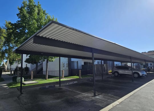 a covered parking lot with cars parked under a canopy at Alturas Paso Robles Apartment Homes, Paso Robles, California