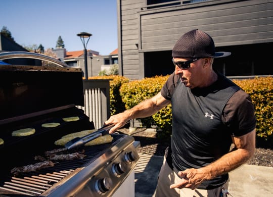 a man grilling food on a barbecue grill