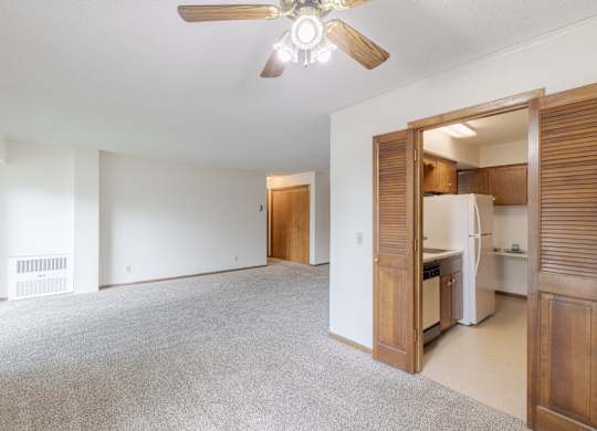A room with a ceiling fan and a carpeted floor.