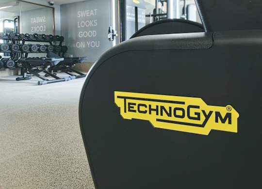A close up of a black Technogym machine in a gym.