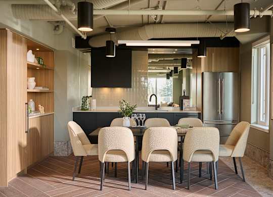 A modern dining room with a long table and chairs.