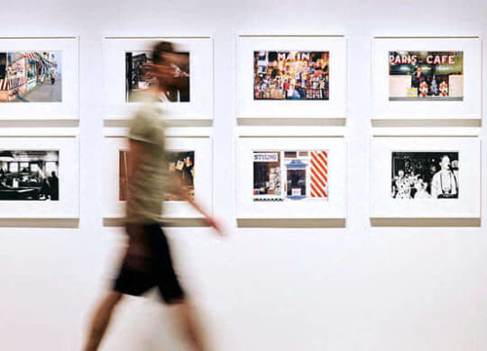 a person walking past pictures on a wall