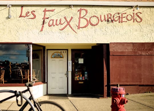 a red fire hydrant in front of a store with a bike