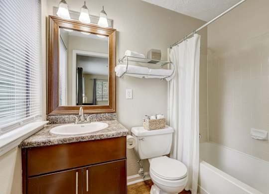 A bathroom with a toilet, sink, and shower.