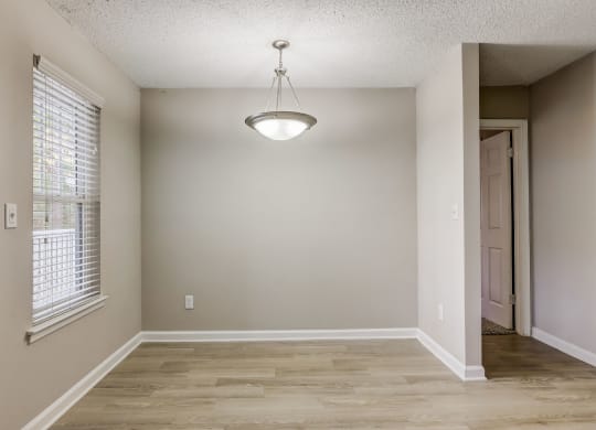 a dining room space with a window and a silver light hanging from the ceiling at Veridian at Sandy Springs