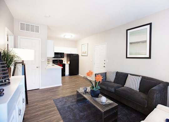 A living room with a black couch and a coffee table.