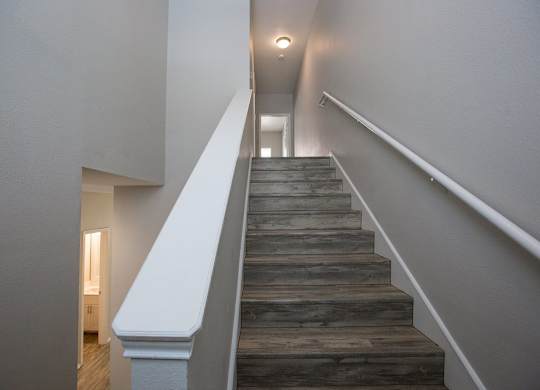 A staircase with wooden steps and white railings.