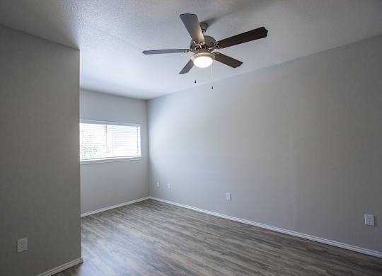 A room with a ceiling fan and a window.