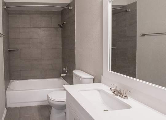 A white toilet sits next to a white sink in a bathroom.