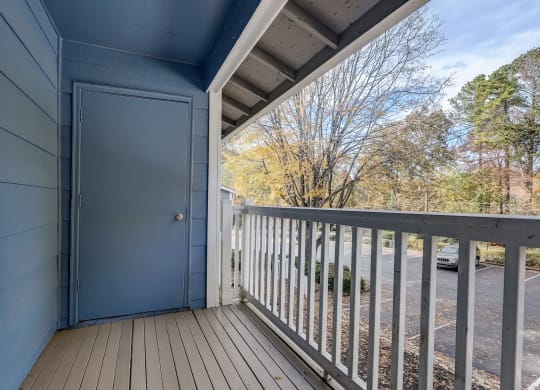 the view from the deck of a blue house with a blue door and a balcony