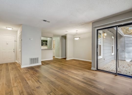an open living room and dining room with a sliding glass door at Veridian at Sandy Springs in Georgia