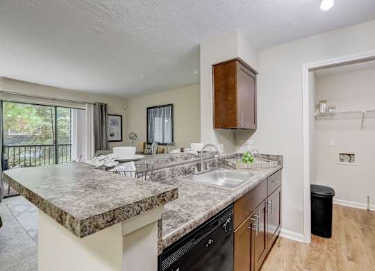 A kitchen with a marble countertop and black appliances.
