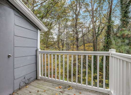 a backyard deck with a garage door and trees