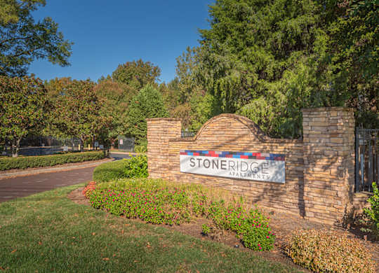 A sign for Stoneridge Apartments is displayed in front of a building.
