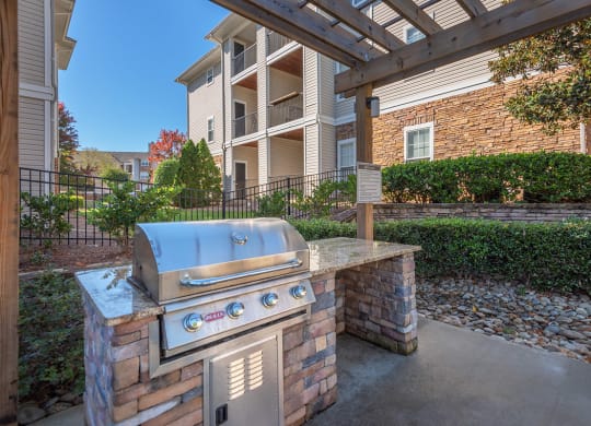 a barbecue grill on a brick wall in front of an apartment building