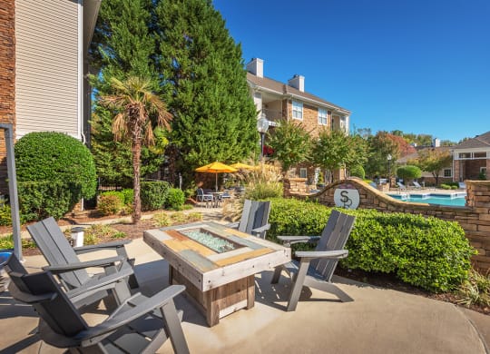 a patio with a table and chairs near a swimming pool