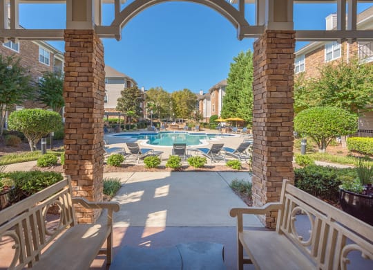 a view of a swimming pool from a patio with benches